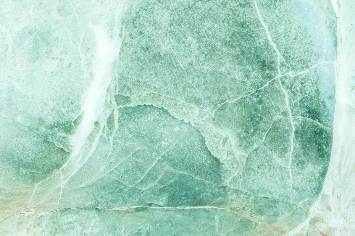 Veines claires courant dans une pierre vert d’eau